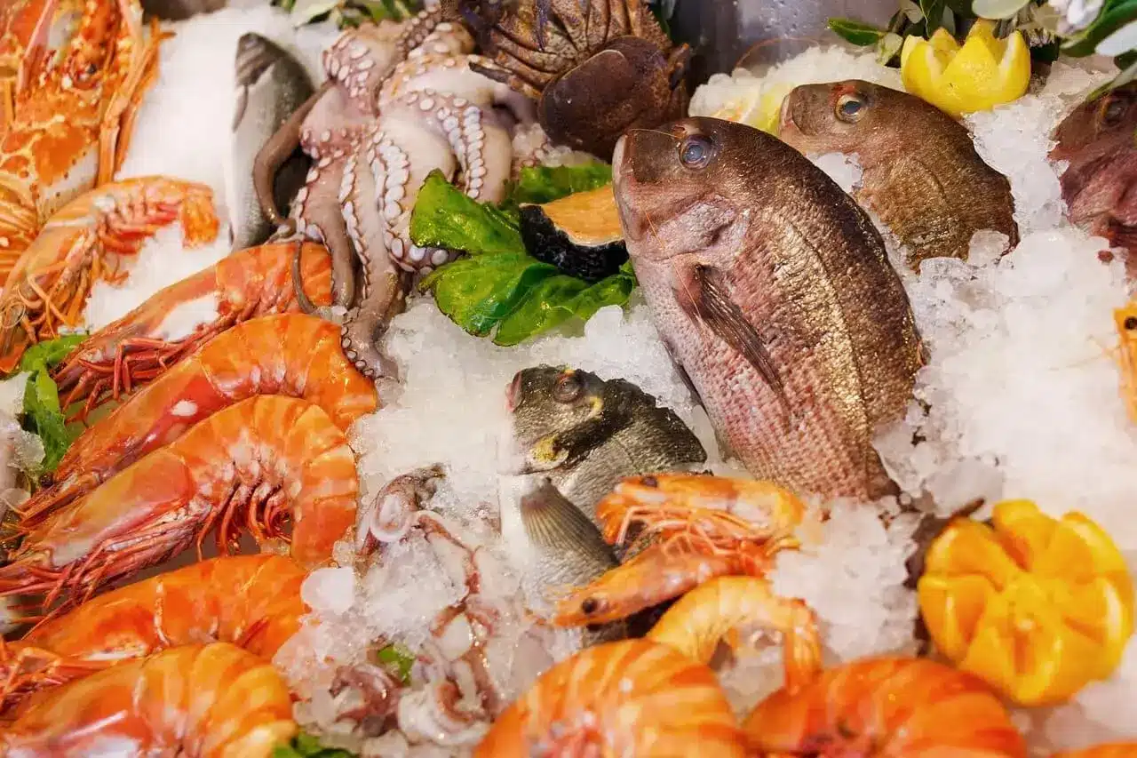 Assorted healthy seafood options suitable for diabetics, including grilled salmon, steamed shrimp, and baked cod, displayed on a well-arranged dinner table.
